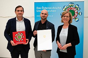 Das Bild zeigt Herwig Sumetzberger (Direktionsleiter RC) und Geschäftsführer Markus walzek mit Leonore Gewessler bei der Verleihung des Umweltzeichens.